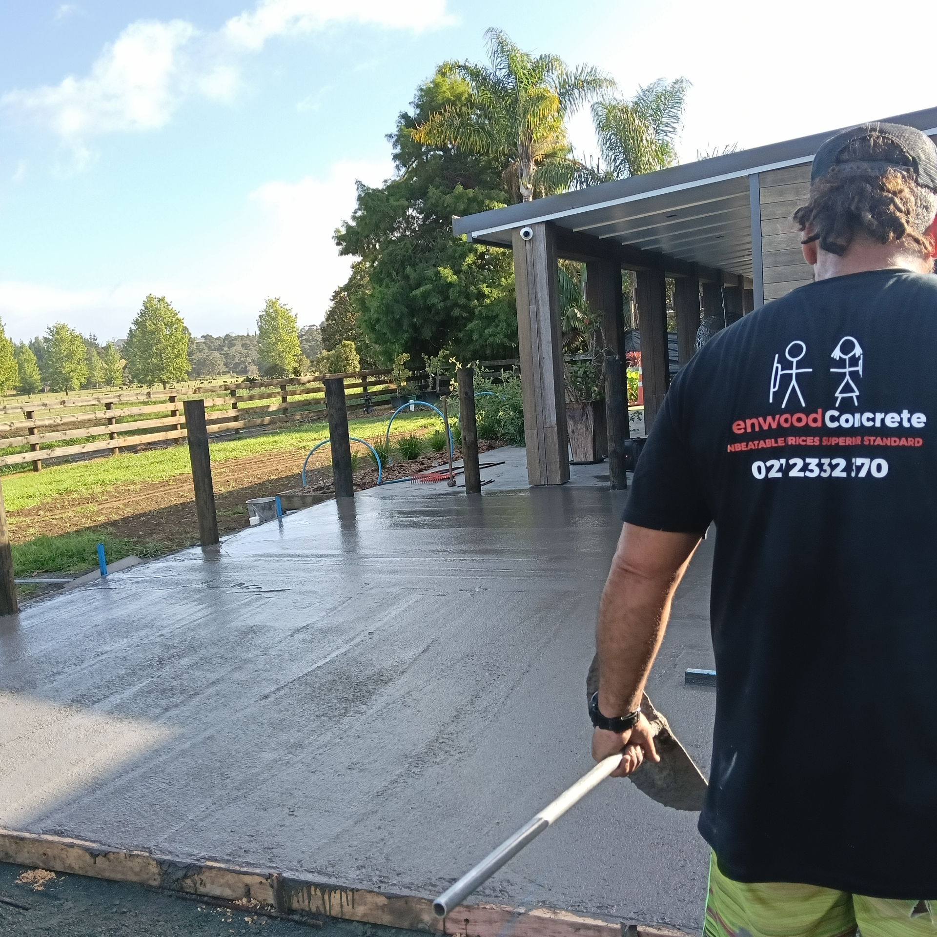 Henwood Concrete crew placing and hand-finishing a black oxide concrete patio.